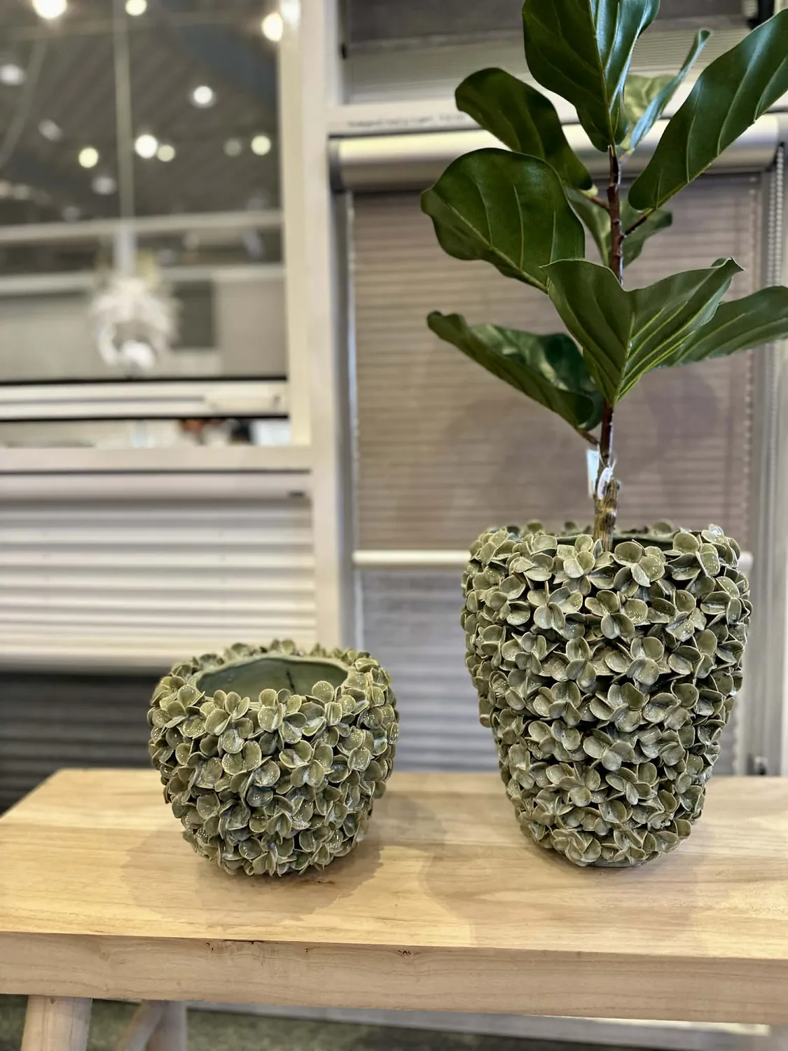 Lille træbord med grønne keramikkrukker og plante